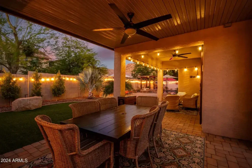 Covered patio with table, chairs and string lights at dusk