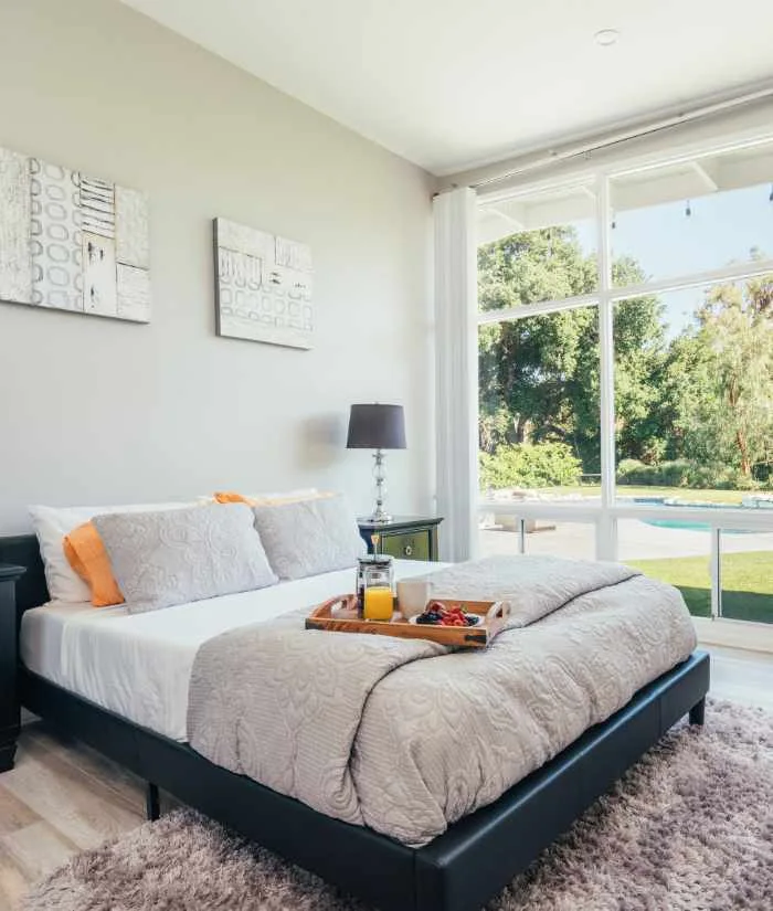 Journey Hillside bedroom with large window and bedside table