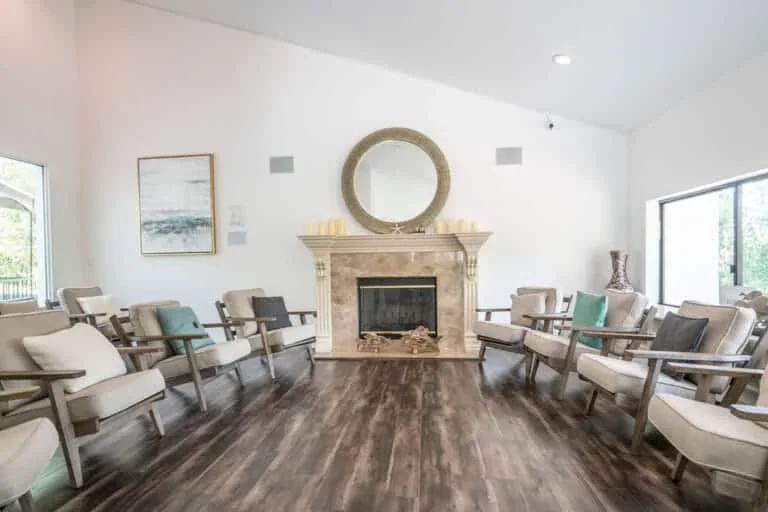 Circle of chairs around a fireplace at Sanctuary