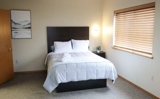 Bedroom with bed, window and bedside lamp at Sequoia
