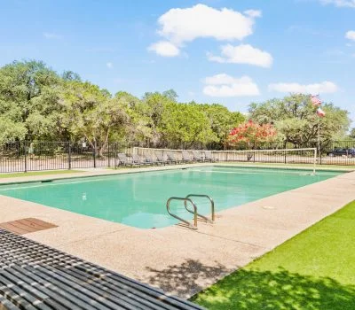 Windmill outdoor swimming pool surrounded by lawn and trees